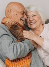 Casal de idosos abraçados no sofá - Alzheimer