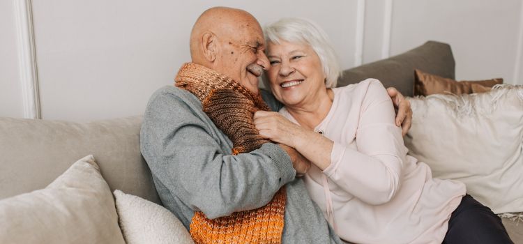 Casal de idosos abraçados no sofá - Alzheimer